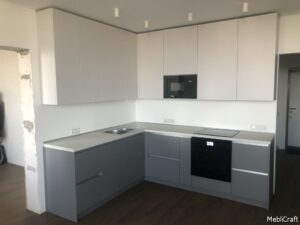 Біло-сіра кутова кухня з вбудованою микрохвильовою пічкою